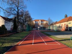 Schulgebäude und Turnhalle mit Gedenktafel